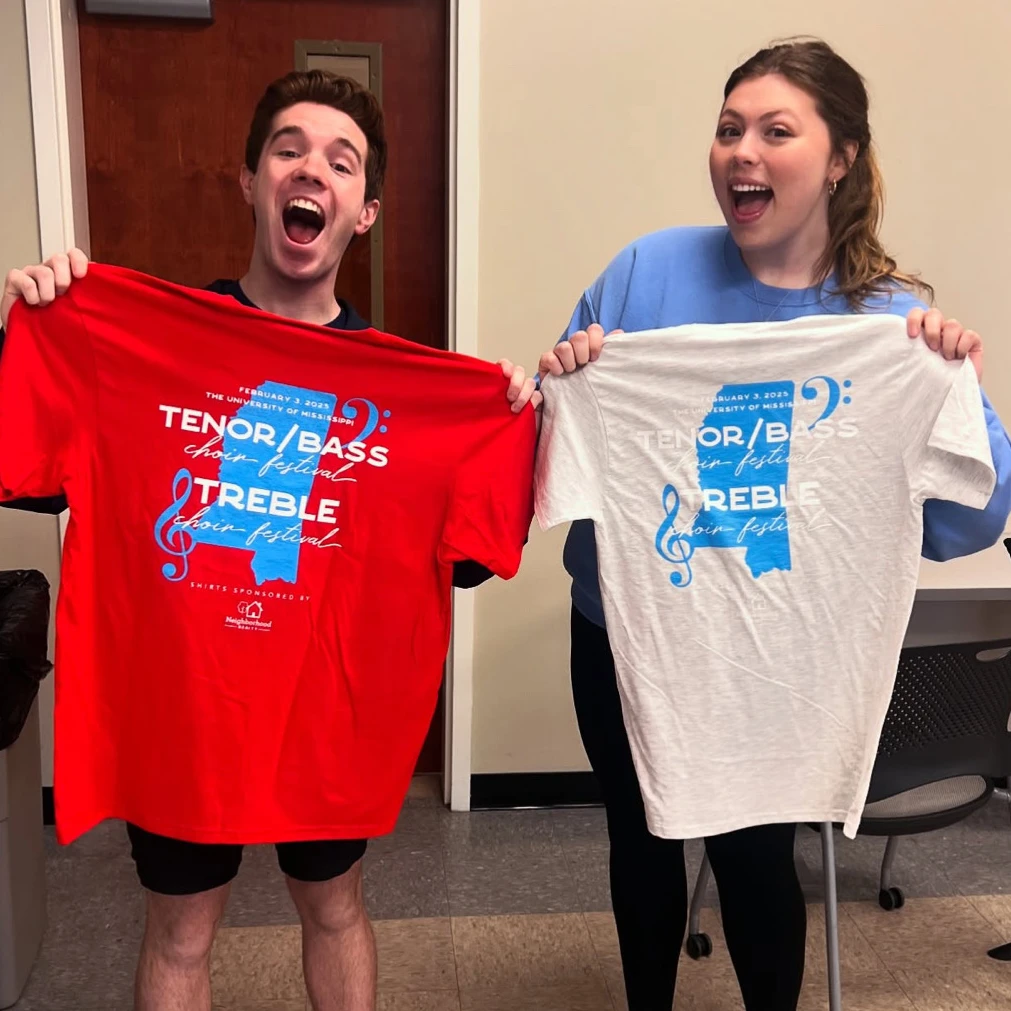 Choir students hold t-shirts screen printed with the choir festival graphic across the back