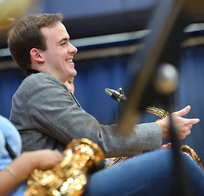 Band member smiles and laughs in band class