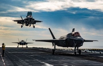 image of planes coming into a landing on aircraft carrier