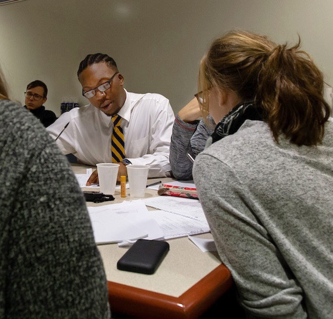 image of students studying while seated around a table