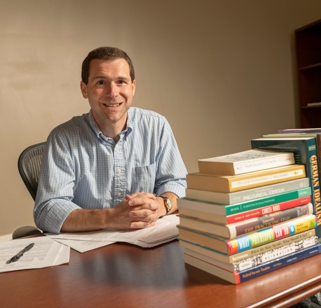 Aaron Graham sitting at his desk in his office
