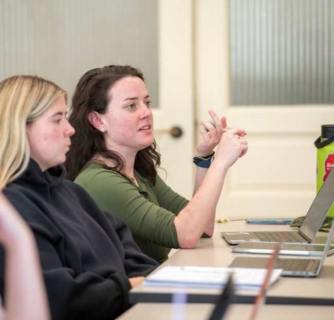 image of a student gesturing with her hand as she talks in class