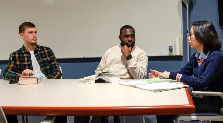 image of three students seated at a table talking