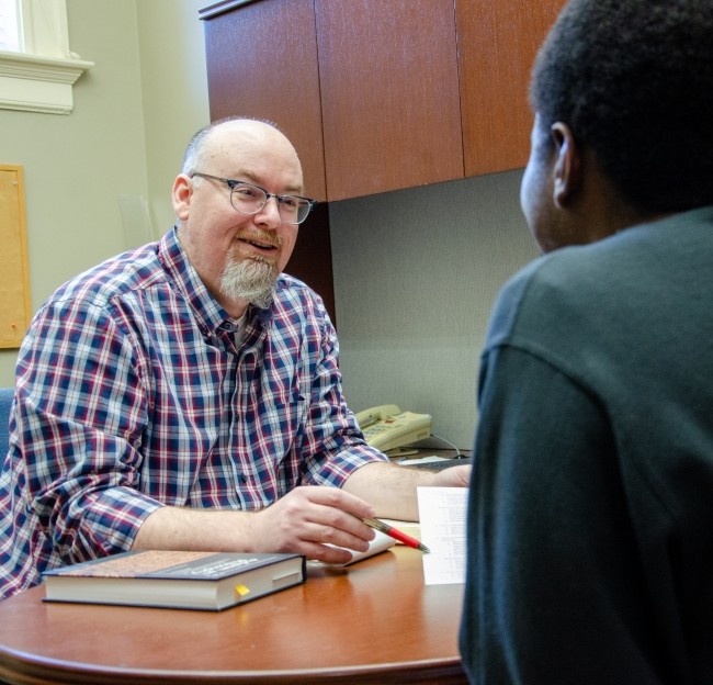 James Bos in his office talking with a student