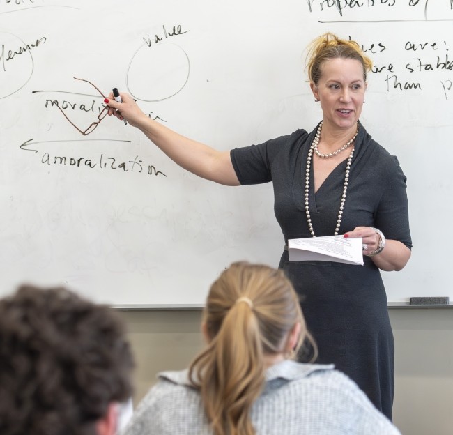 Deborah Mower director of the Center for Practical Ethics points to a student in a classroom.