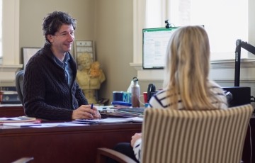 image of professor and student seated in an office talking