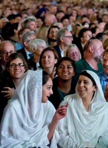 image of a crowd of people of different religious faiths seated on the floor of a large space