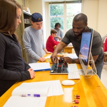 image of two students getting help from a graduate TA in a physics lab
