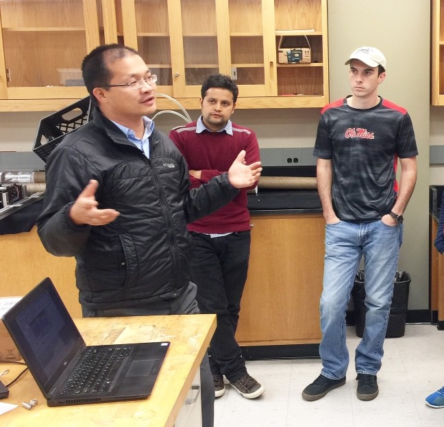 image of faculty member talking to students in his lab