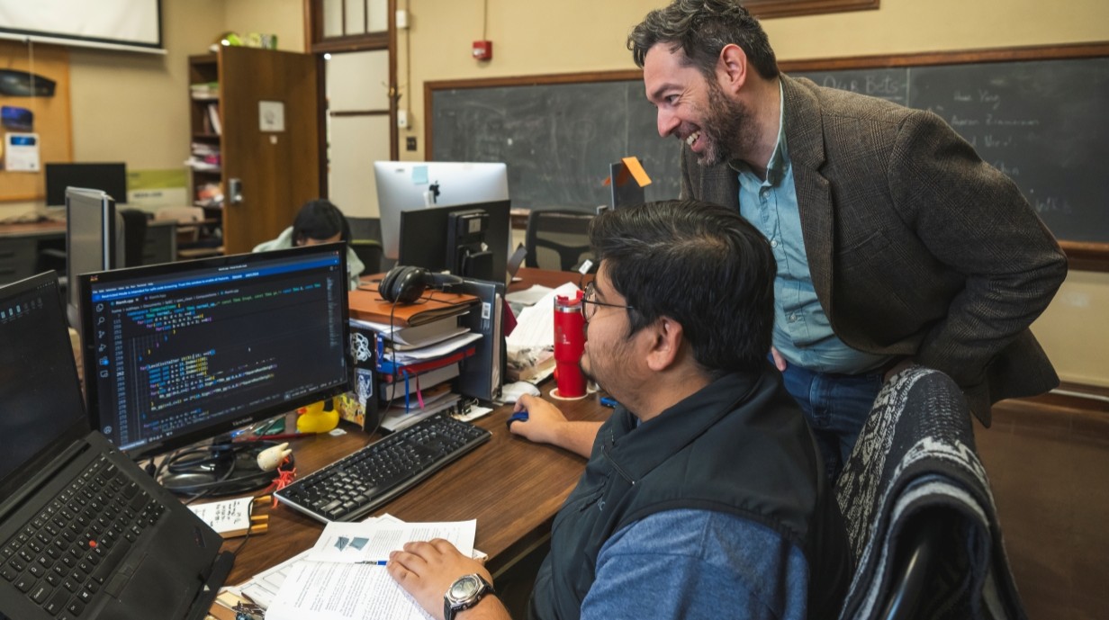 student and faculty member working together at a computer