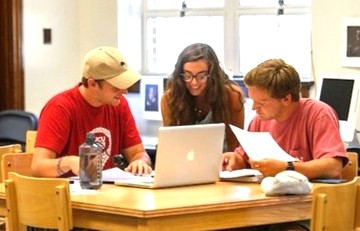 three students studying together around a table