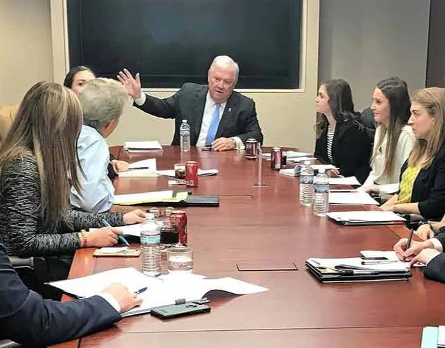 image of Haley Barbour gesturing and talking with a group of students around a table