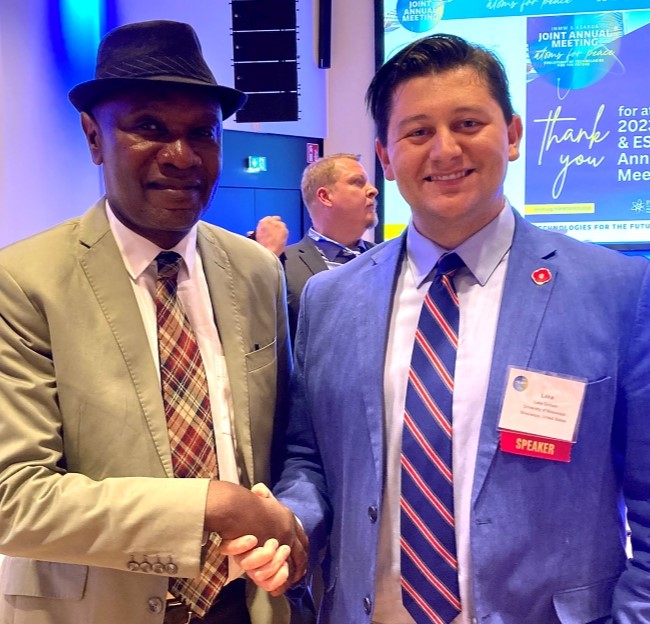 student shaking the hand of an African leader