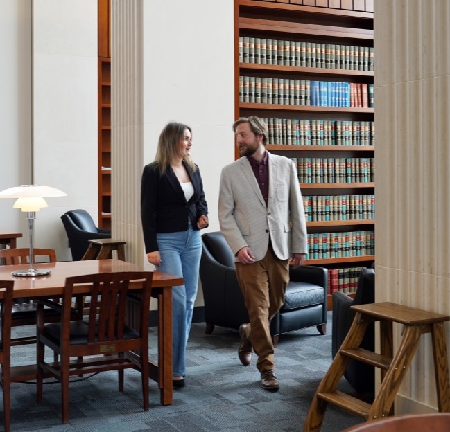 Ella Jordan and a professor walking together in a library