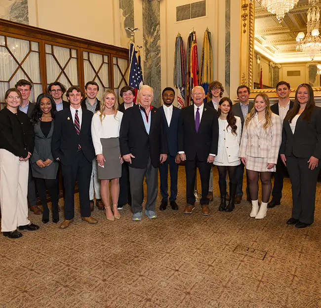 image of students standing in a group with prominent politicians