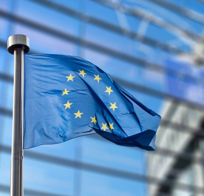 image of a European Union flag in front of a modern building