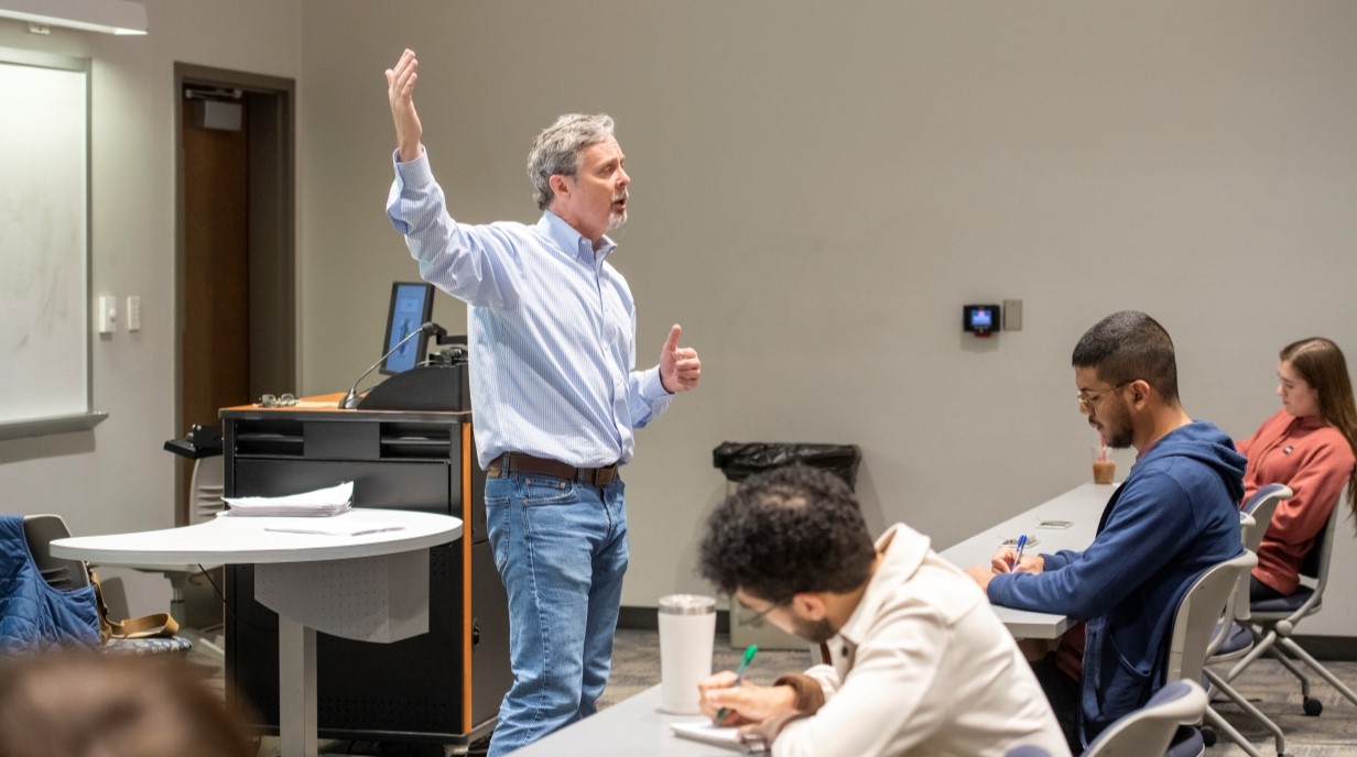 image of Tim Nordstrom gesturing as he speaks in front of a classroom 