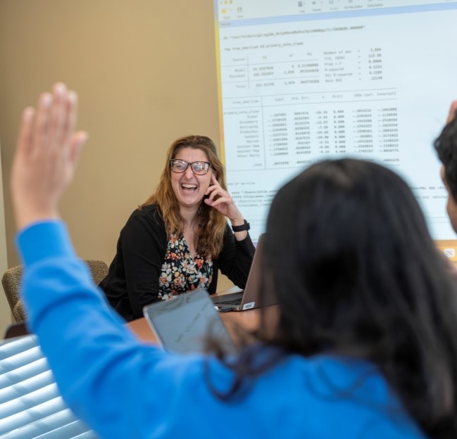 faculty member smiling at students in a graduate course