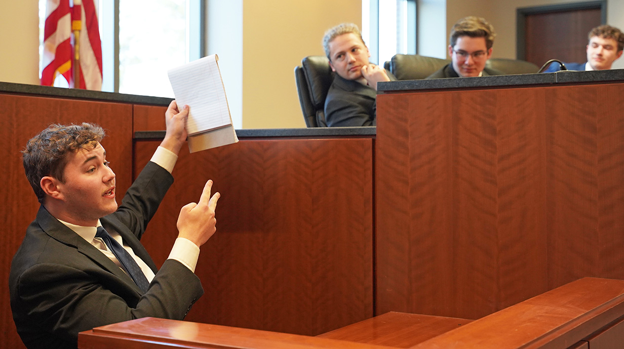 man sitting at the judges stand in a mock trial