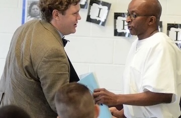 student and teacher shake hands at graduation ceremony