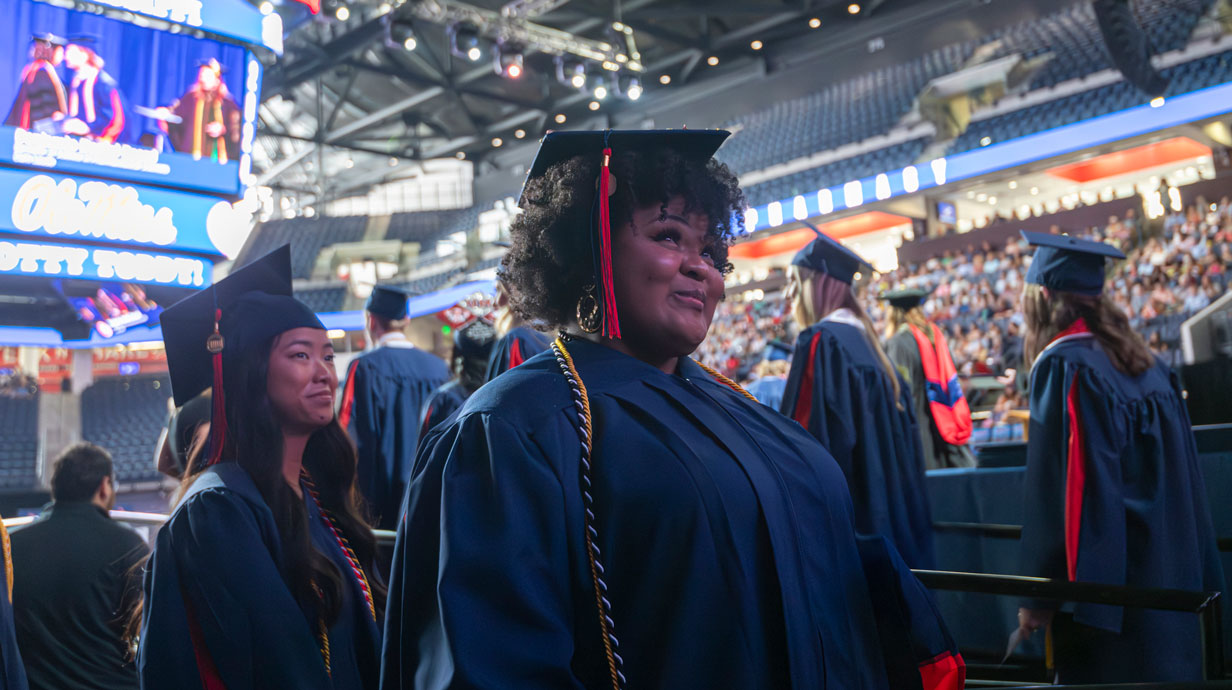 two students in graduation regalia