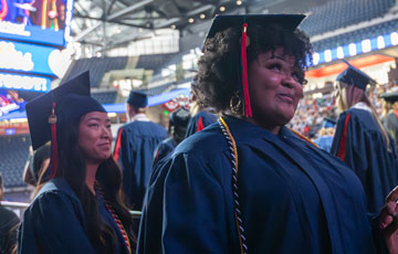 two students in graduation regalia