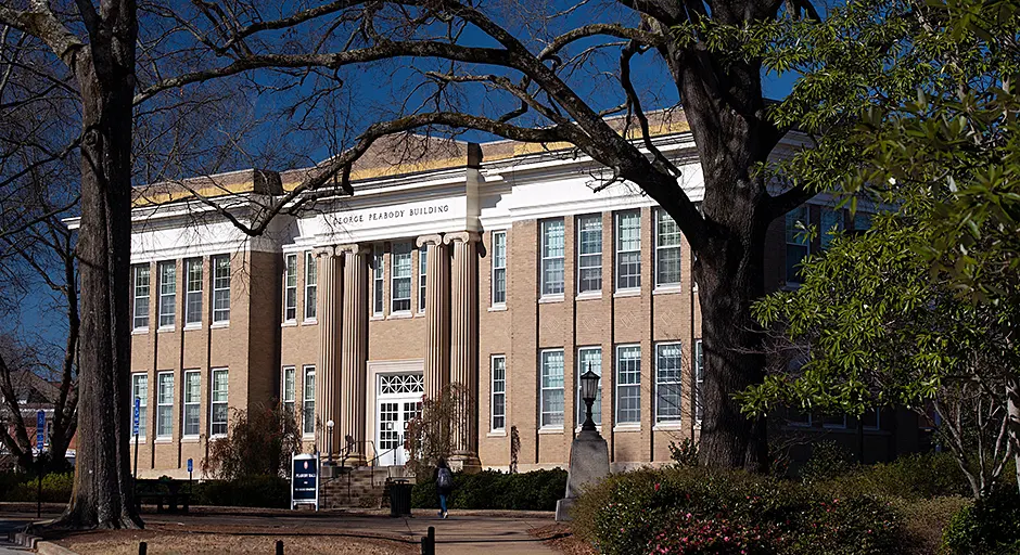exterior of light brown brick building with 4 columns 