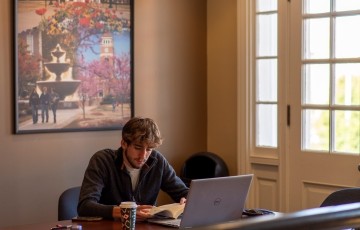 student seated at table at a laptop