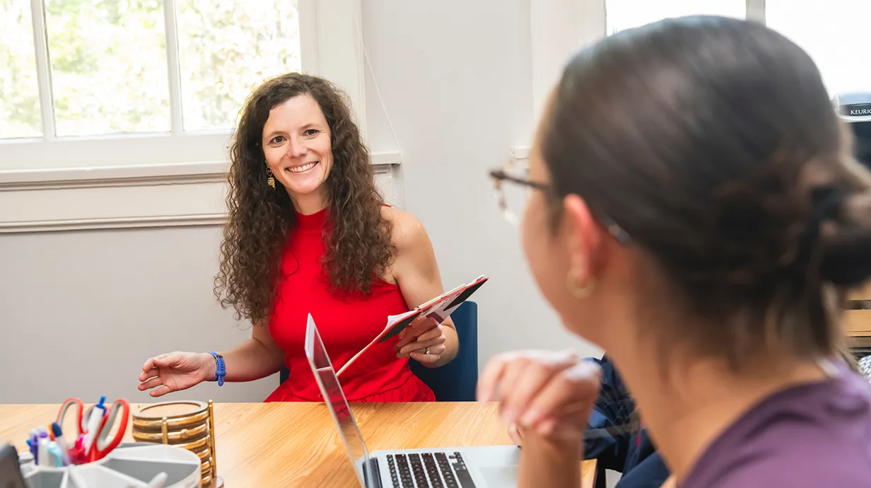 Professor and student sitting at a table.