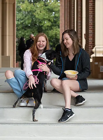 image of two students petting a dog