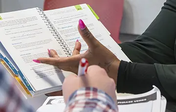 Hands in front of writing text book.