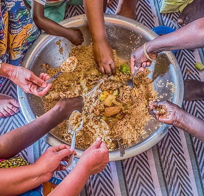 Senegal family eating together in the traditional manner