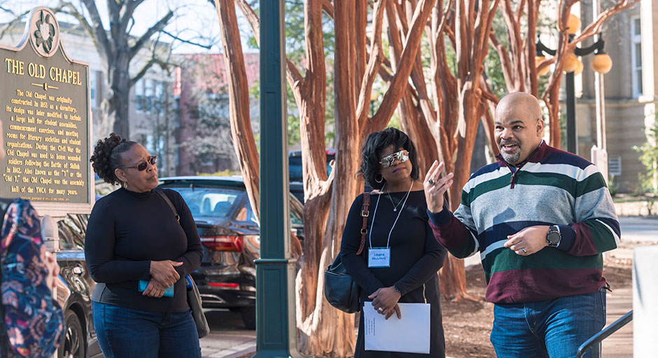man giving a tour of campus to people