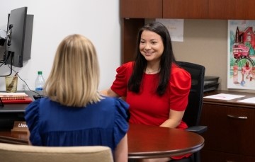 staff member and student seated in an office talking