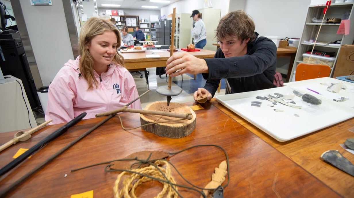 image of two students manipulating artifacts in a bioarchaeology course