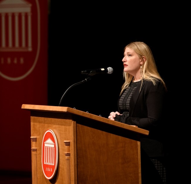 image of Kate Centellas on a stage speaking at podium