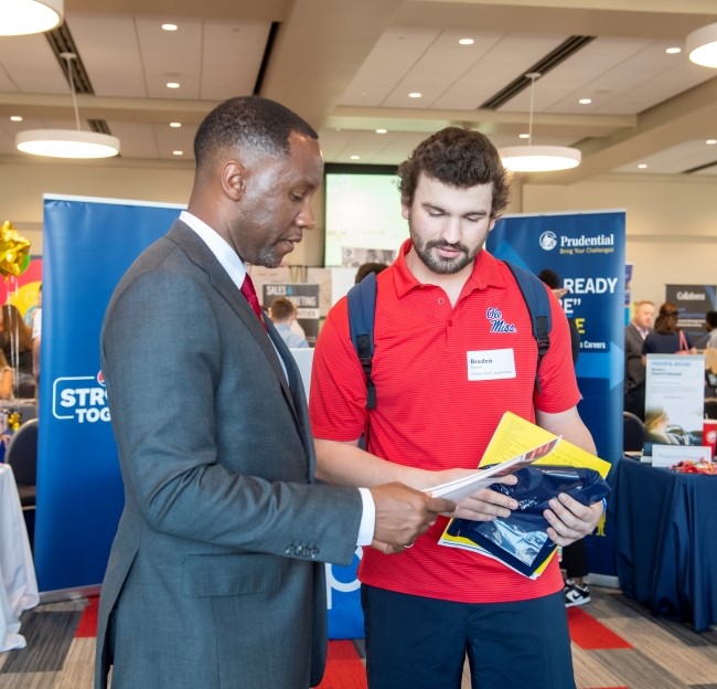 image of student and internship recruiter standing at a career fair