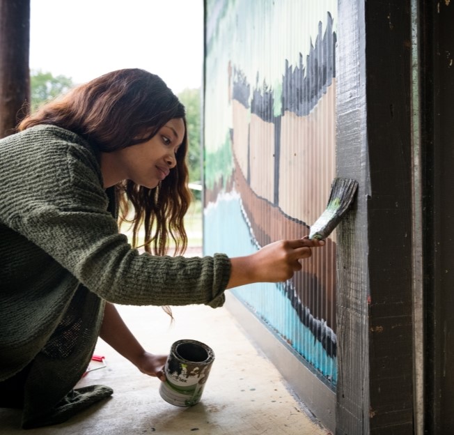 image of a student painting a wall