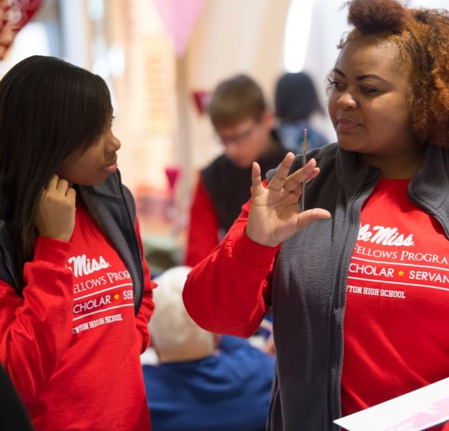 a student and a teacher talking with each other in a crowd