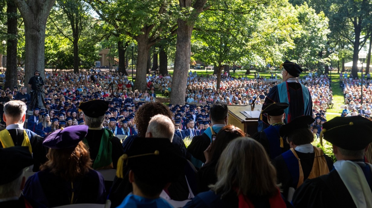 image of the outdoor graduation ceremony under the trees in the Grove