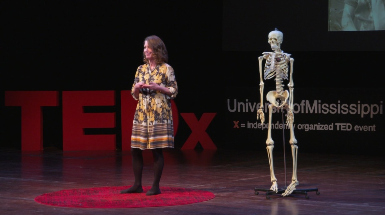 image of Caroline Freiwald on stage with a skeleton