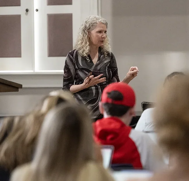 Person standing talking to members of a class