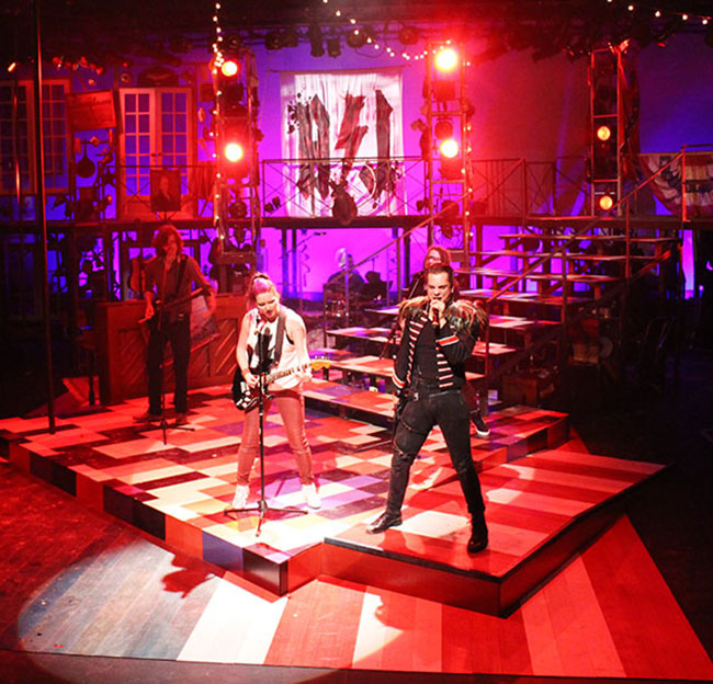 band actors on stage with red lighting