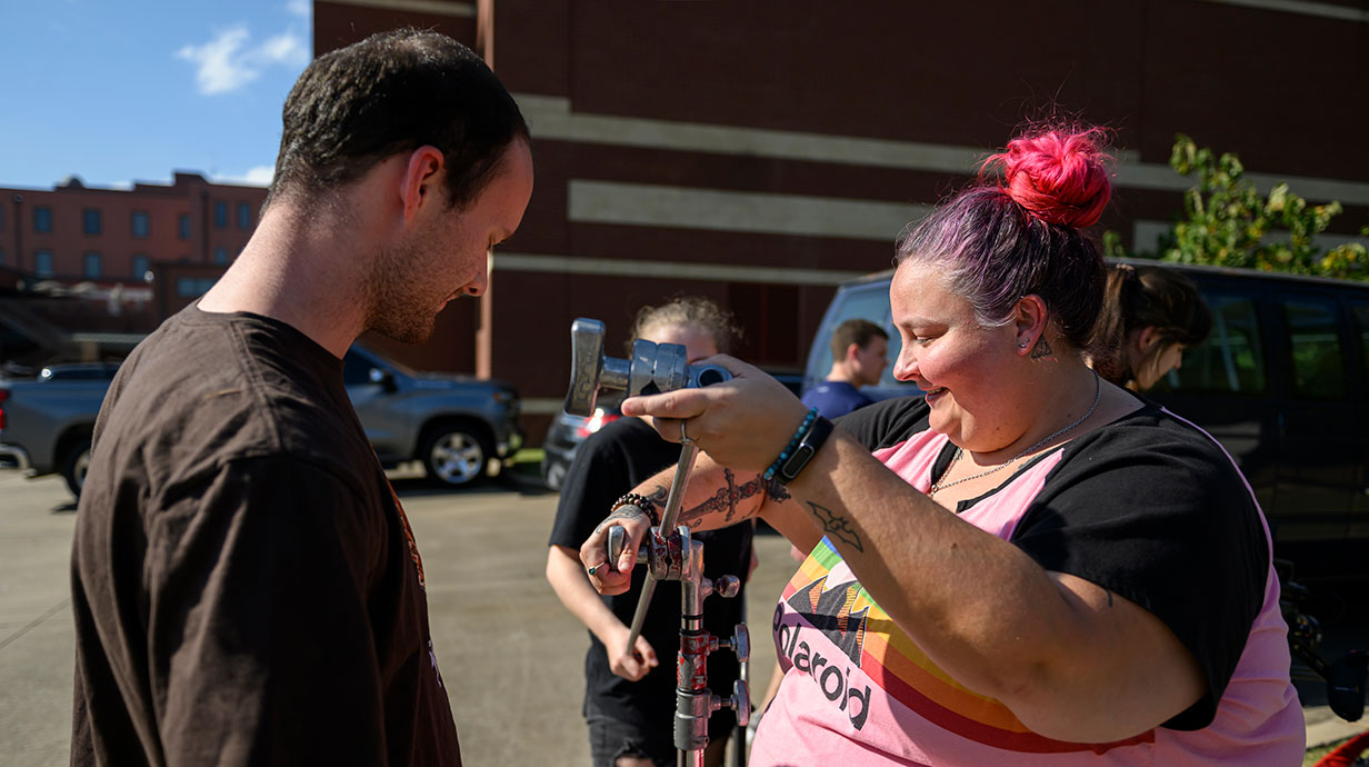 faculty showing a student a piece of film equipment