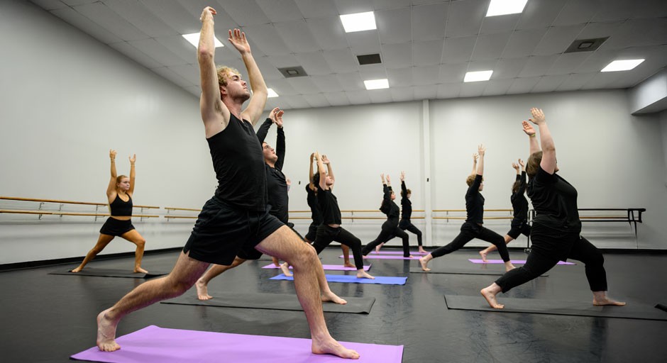 image of students doing yoga poses in a studio classroom