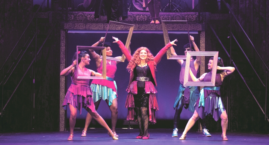 students posing on stage in costumes