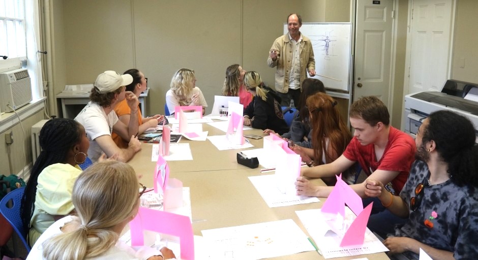 image of a small class around a conference table with paper models in front of them