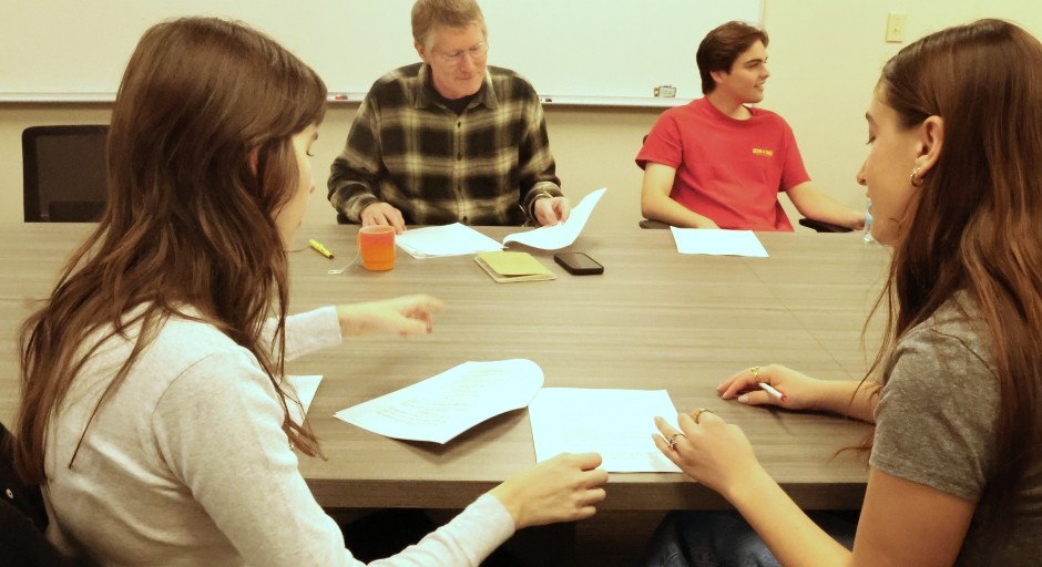 students seated together and working on a script
