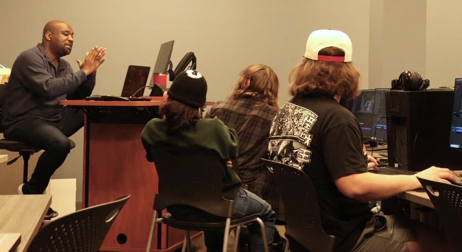 students and faculty talking together in a computer lab