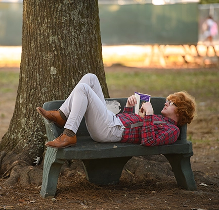 Student reading in the Grove